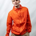 Man wearing an orange jacket against a plain background