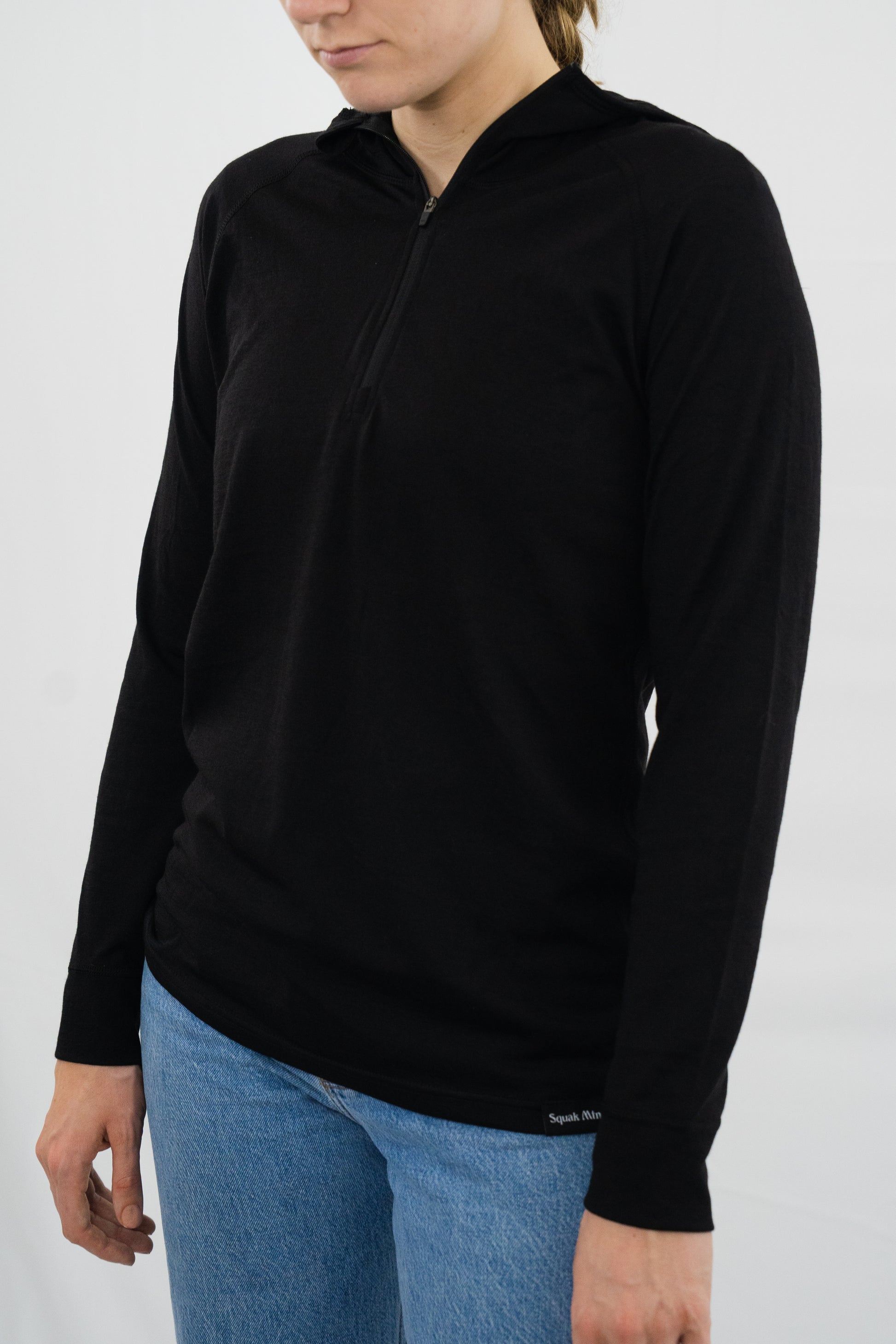 Person wearing womens black wool base layer hoodie from Squak Mountain Co.