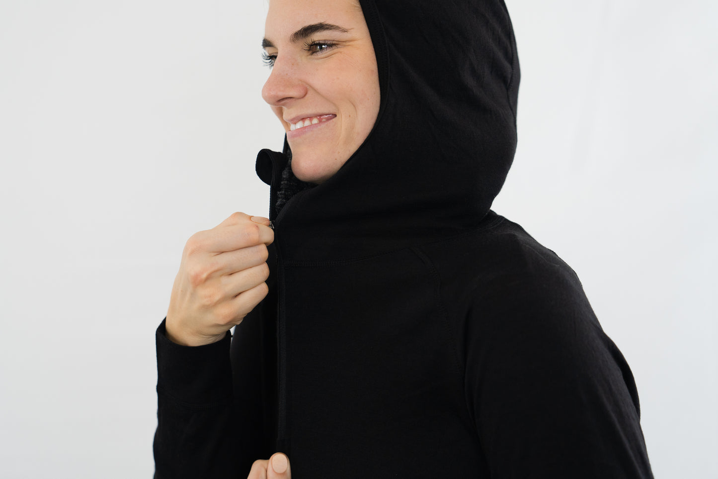 Top half of person wearing womens black wool base layer hoodie from Squak Mountain Co.